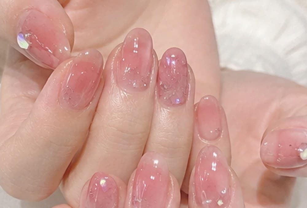 Short round nails in a glossy, see-through pink jelly finish